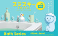 A promotional image featuring a blue creature, Smiski, in a bathroom setting with various bath-related items such as a soap dispenser, toothbrushes, and a bath caddy. The image has Japanese text and is labeled as part of the 'Smiski Bath Series' with a tag indicating 6 kinds plus a secret.