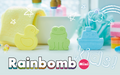 An image featuring three mini bath bombs shaped like a duck, boat, and frog, in a pastel color palette with the text 'Rainbomb Mini' and 'kids!' prominently displayed.
